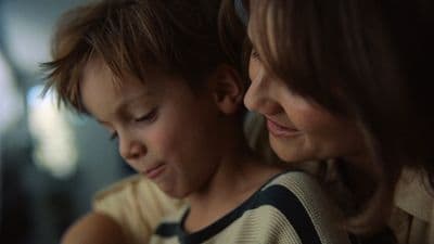 a woman and a child looking at a cell phone
