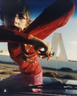a woman in a red shirt holding a cell phone