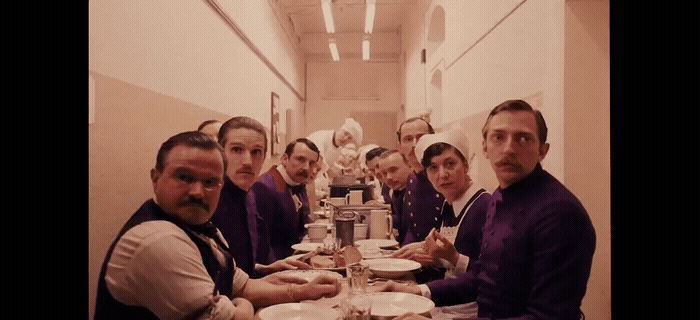 a group of people sitting at a long table