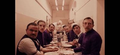 a group of people sitting at a long table