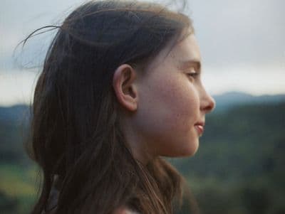 a woman with long hair looking off into the distance