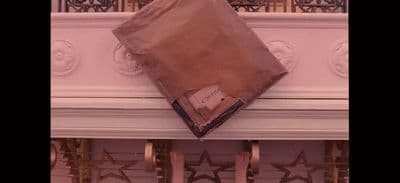 a brown bag sitting on top of a white mantle