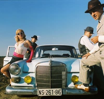 a group of people sitting on the hood of a car