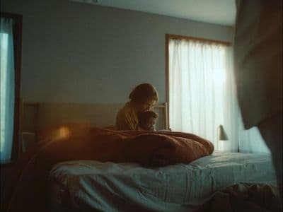a person sitting on a bed with a laptop