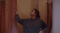 a woman standing in front of a curtain in a room