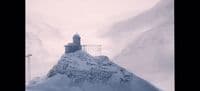 a mountain covered in snow with a clock tower on top