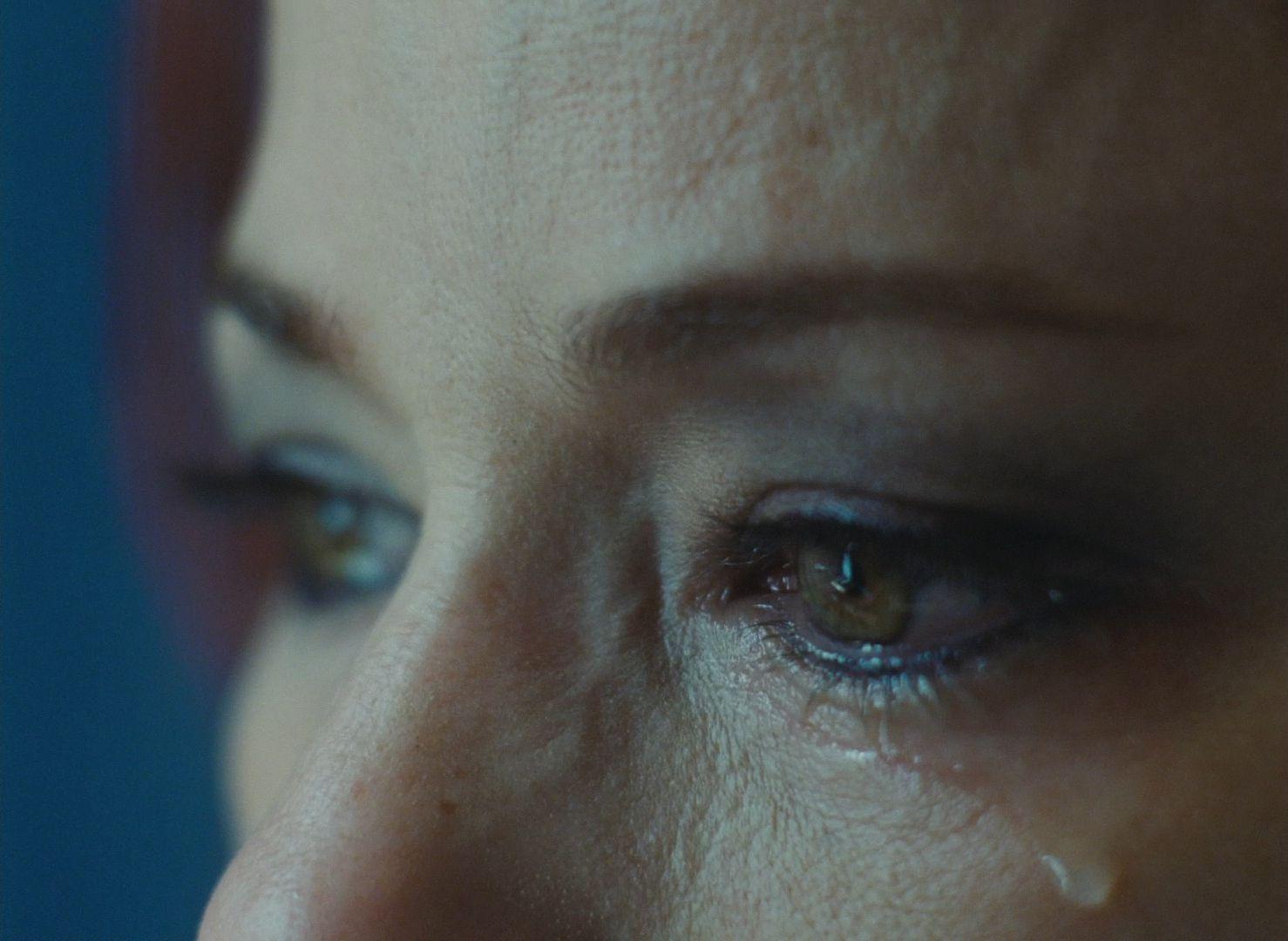 a close up of a woman's eye with tears