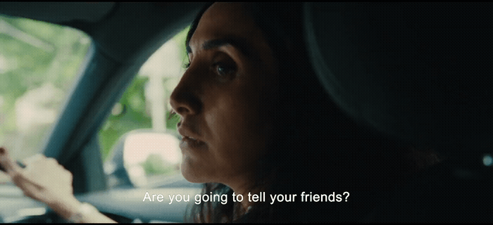 a woman driving a car with a cell phone in her hand