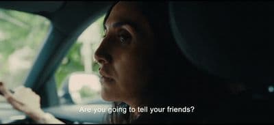 a woman driving a car with a cell phone in her hand