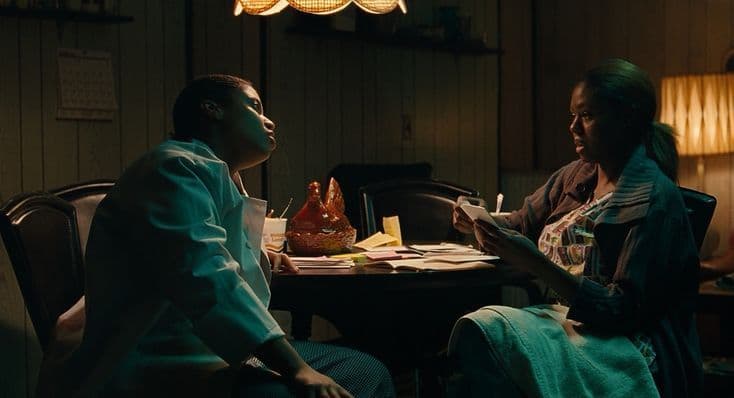 two people sitting at a table in a dark room