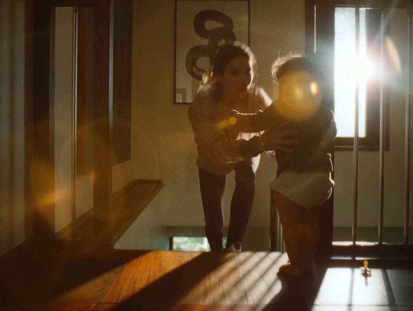 a woman standing next to a child in a room