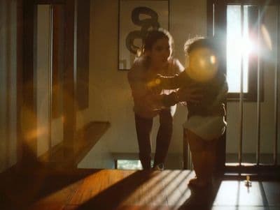a woman standing next to a child in a room