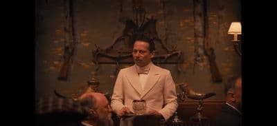 a man in a tuxedo holding a tray of food