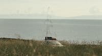 a car parked on the side of a hill near the ocean
