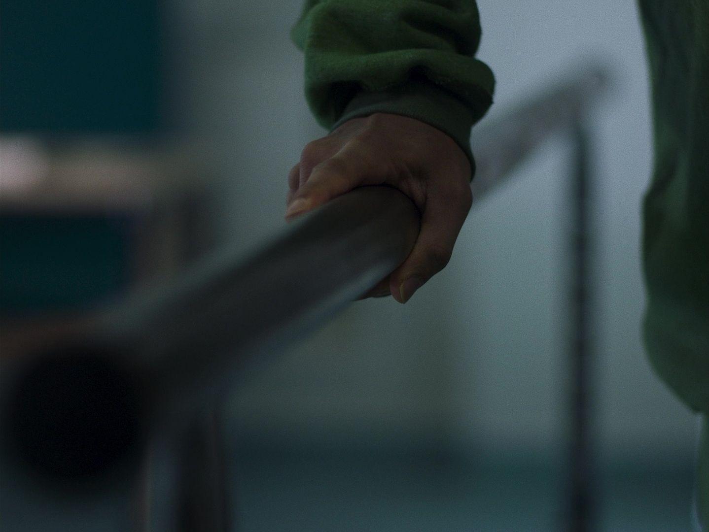 a person holding onto a railing with their hand
