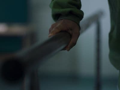 a person holding onto a railing with their hand