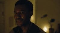 a man in a dimly lit room looking at the camera