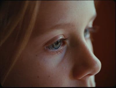 a close up of a child's face with blue eyes