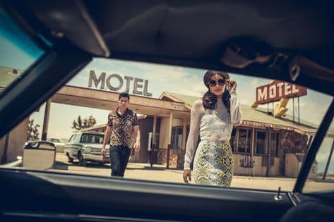 a man and a woman walking in front of a motel