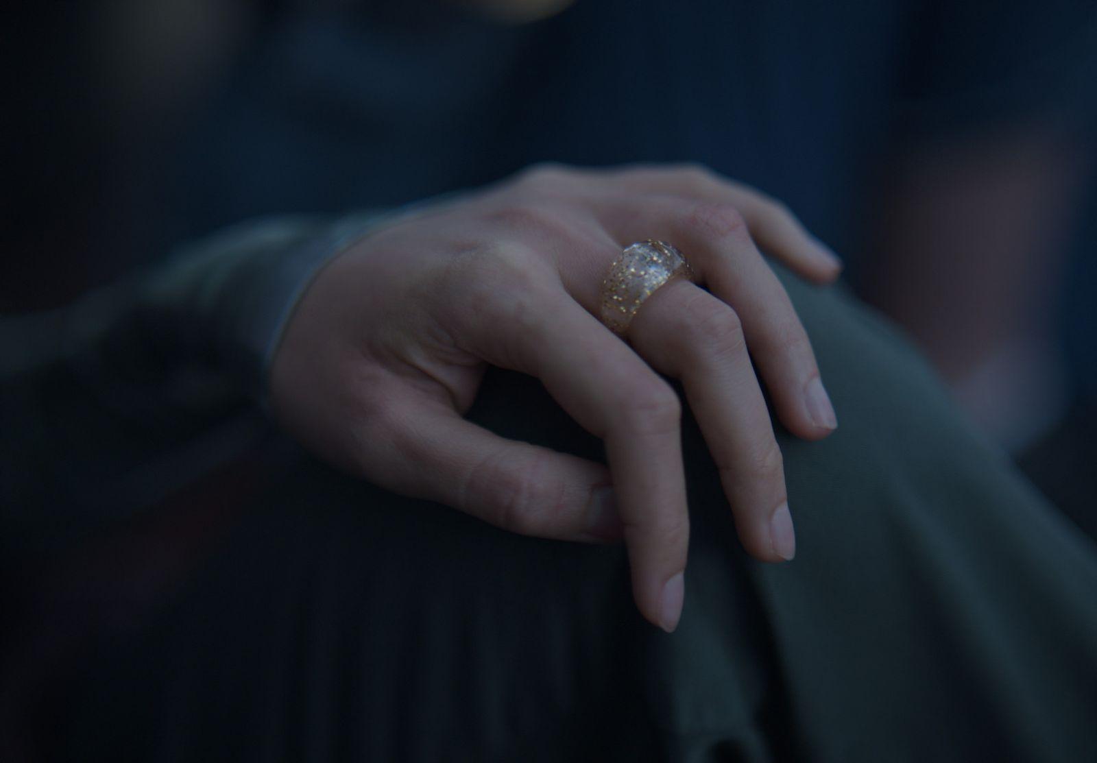 a close up of a person's hand with a ring on it