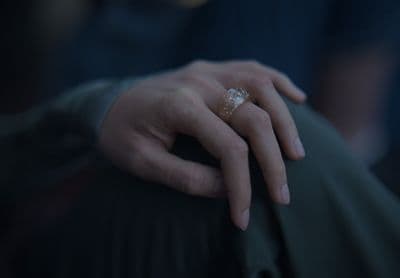 a close up of a person's hand with a ring on it