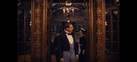 a man in a tuxedo standing in front of a mirror