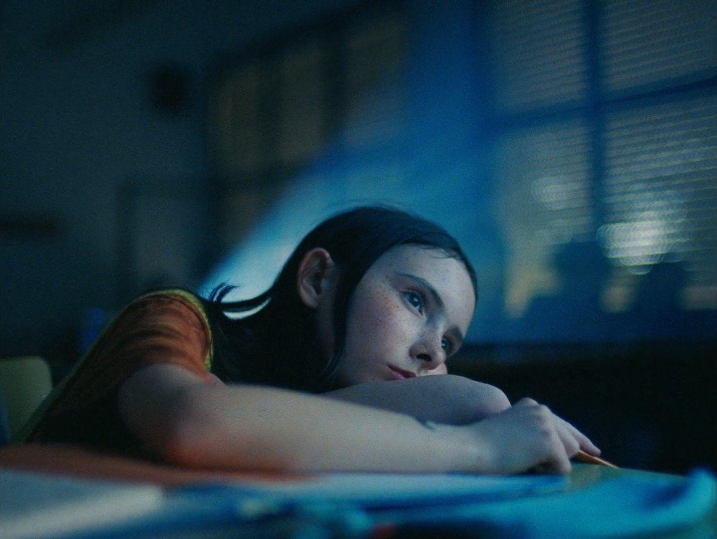 a woman laying on top of a bed next to a window