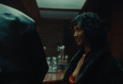 a woman in a fur coat sitting at a bar