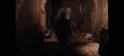 a man is walking through a dark tunnel