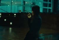 a woman smoking a cigarette on a city street
