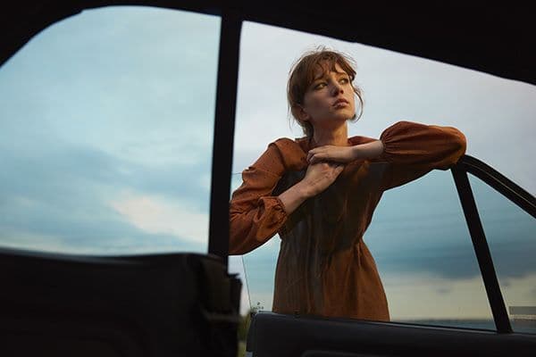 a woman standing in the drivers seat of a car