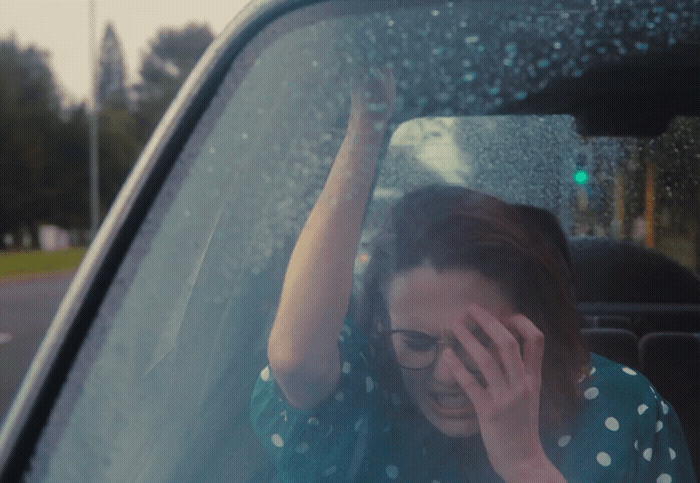 a woman sitting in a car talking on a cell phone
