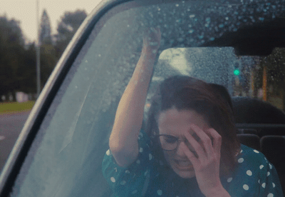 a woman sitting in a car talking on a cell phone