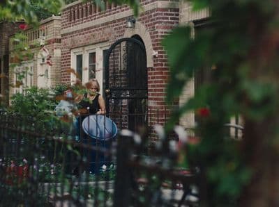 a woman sitting on a bench in front of a building