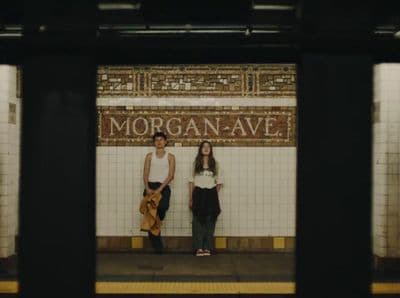 a couple of people standing on a subway platform