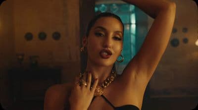 a woman in a black top and gold jewelry
