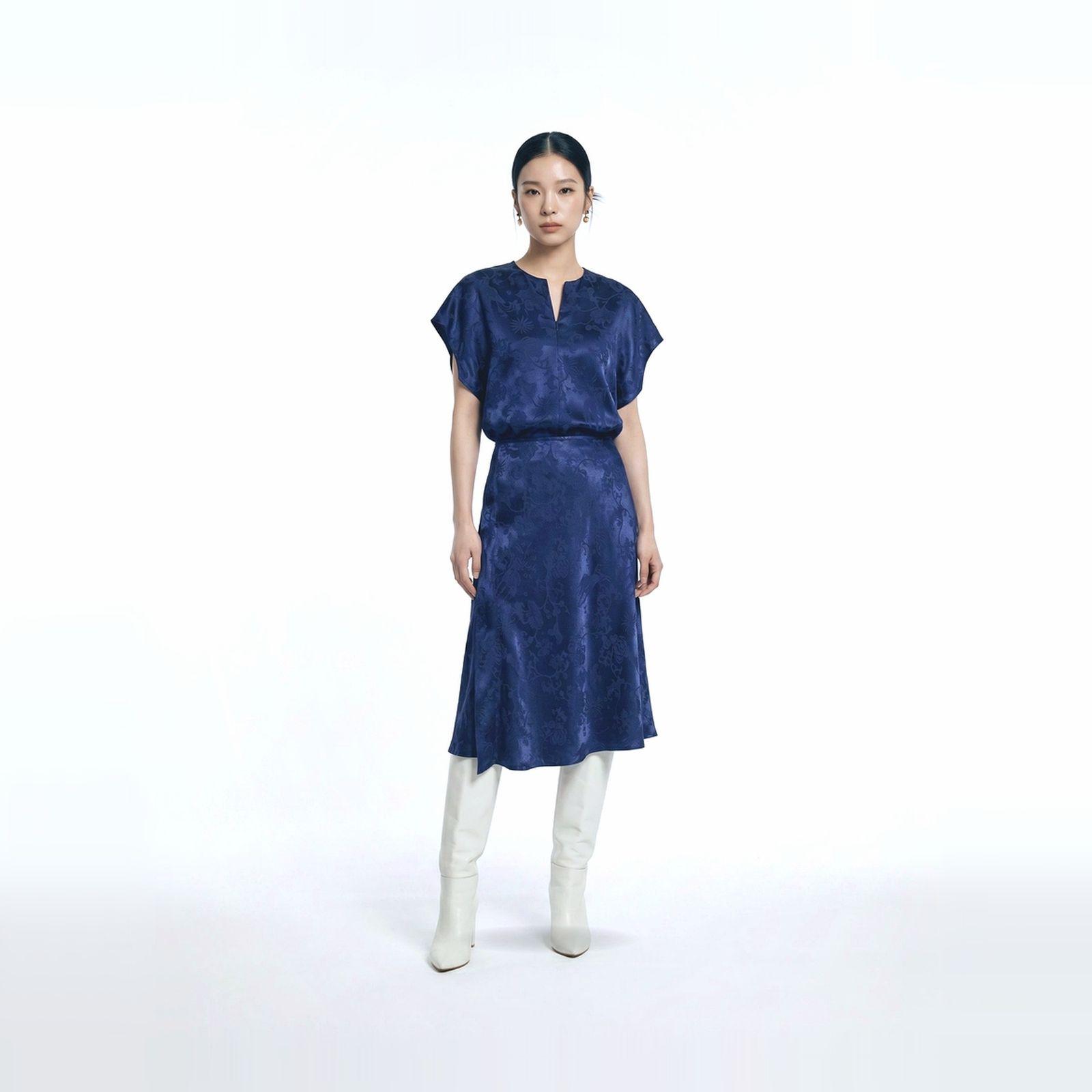 a woman wearing a blue dress and white boots