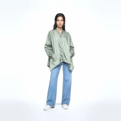 a woman in a green shirt and jeans