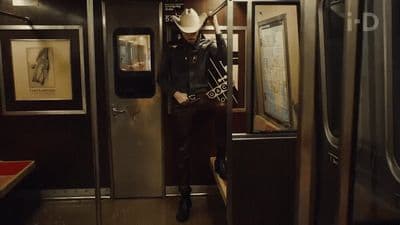 a man in a cowboy hat standing on a train