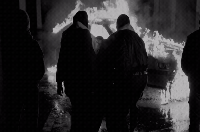 a group of people standing in front of a fire