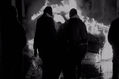 a group of people standing in front of a fire