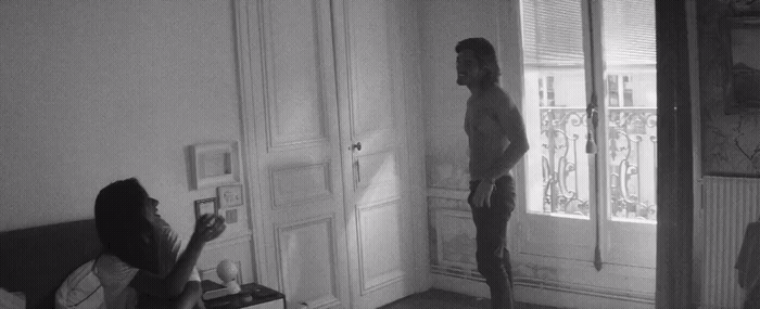 a man standing in a living room next to a woman