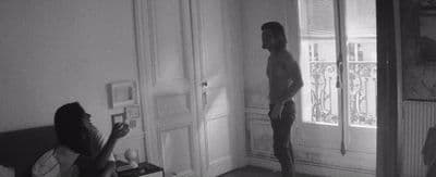 a man standing in a living room next to a woman