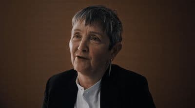a woman in a black jacket and white shirt