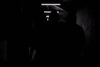 a person standing in a dark room with their back to the camera