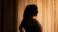 a woman standing in front of a curtain
