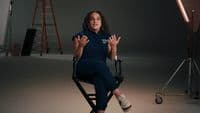 a woman sitting in a chair with her hands in the air