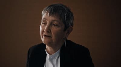 a woman in a black jacket and white shirt