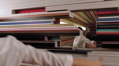 a blurry image of a person reaching for a piece of art