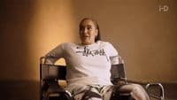 a woman in a white shirt sitting in a chair